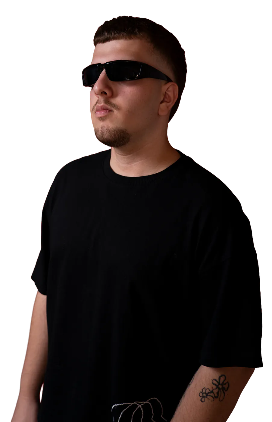 Milli in a black tee and sunglasses, looking to the side